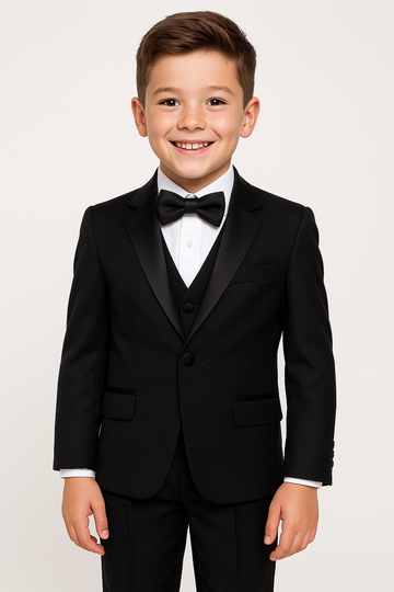 Young boy wearing a black tuxedo with a white shirt and black bow tie