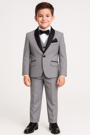 Young boy wearing a gray tuxedo with black lapels and bow tie
