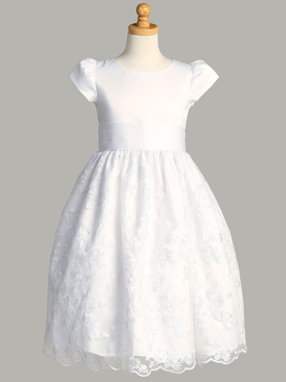 A side view of the First Communion Dress showing the satin bow on the waistline and the tea-length of the dress.