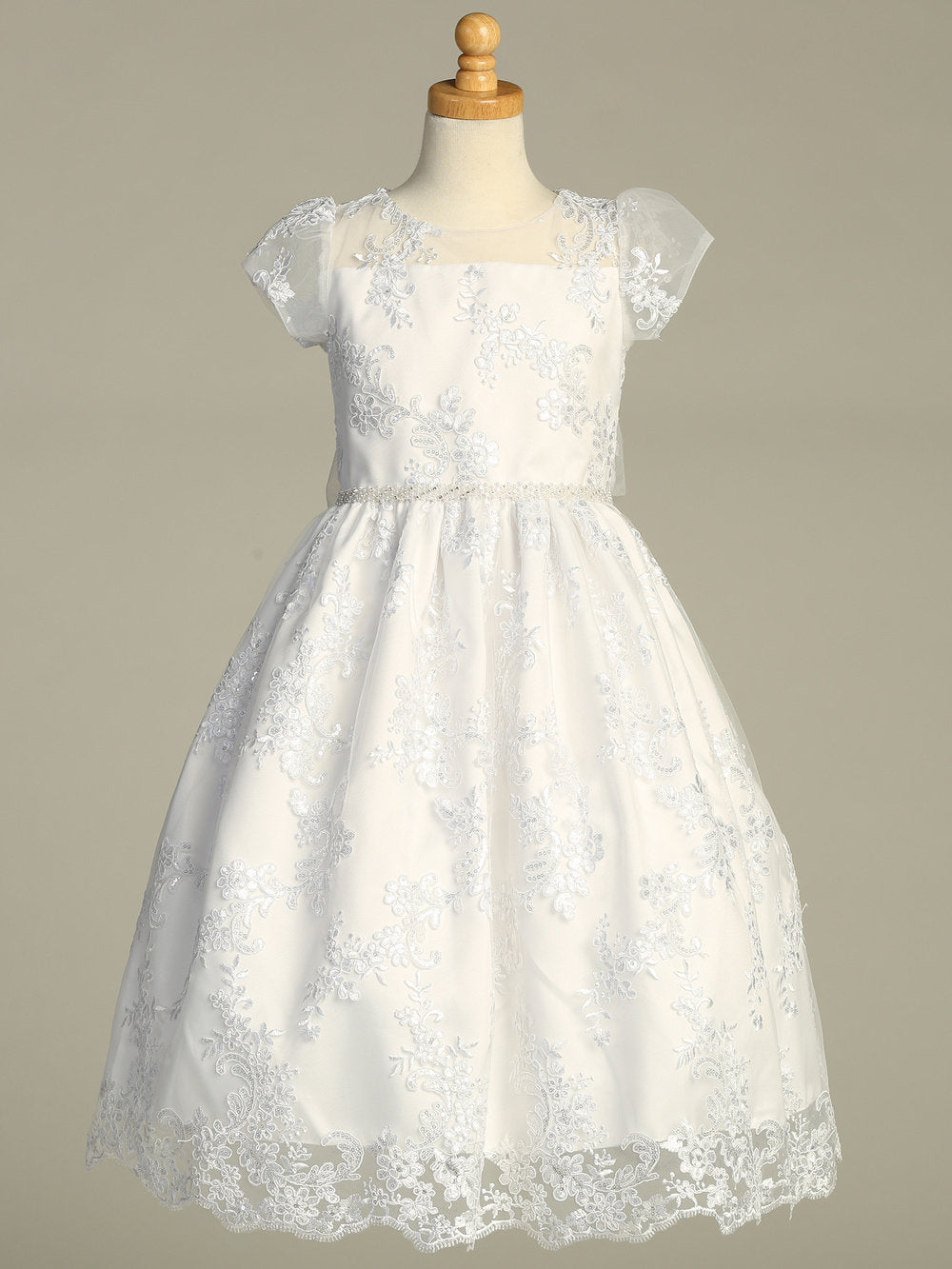 A full-length view of the First Communion Dress showing the elegant silhouette and embroidered tulle with sequins.