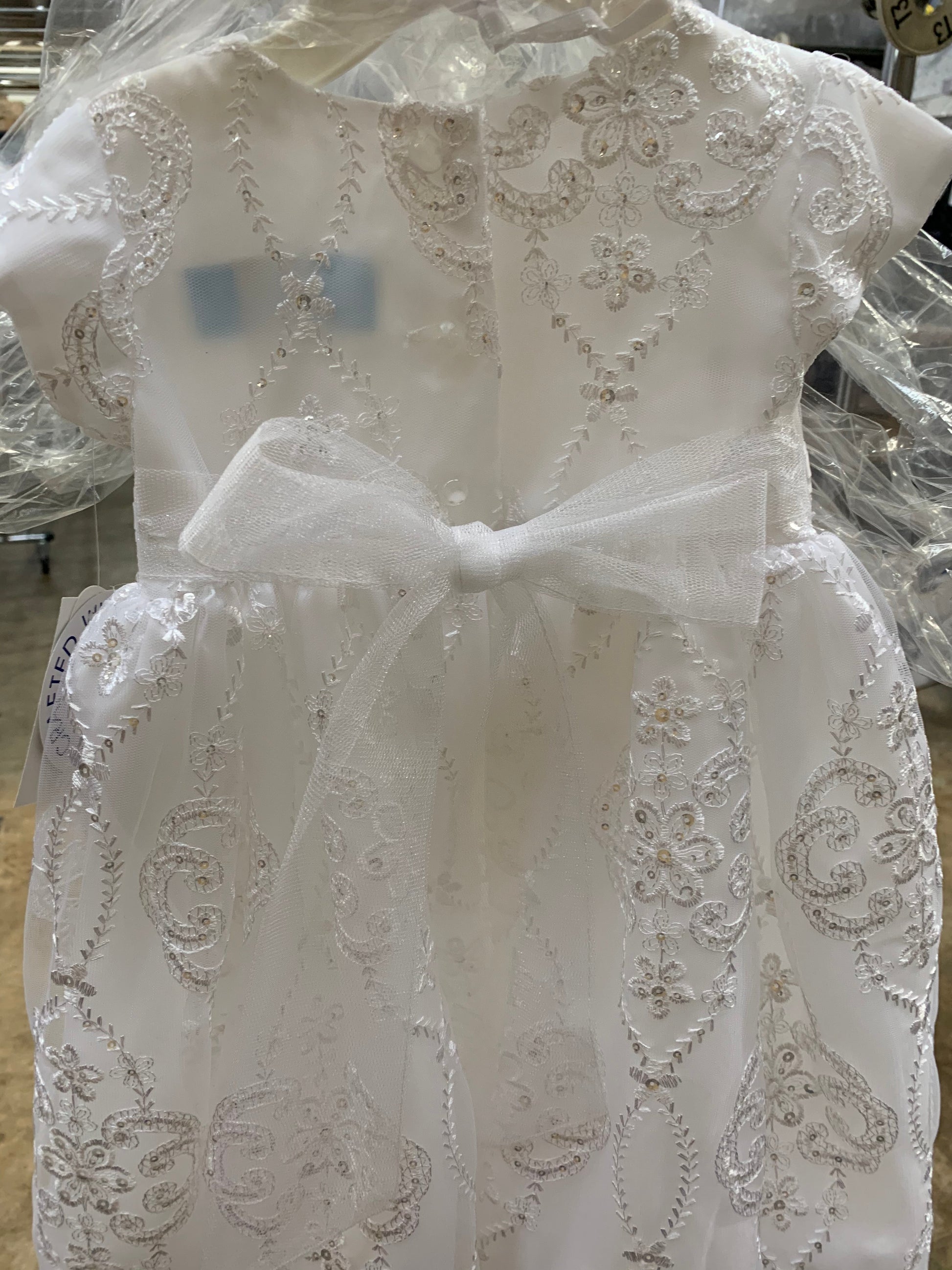 White lace dress on a mannequin with intricate patterns.