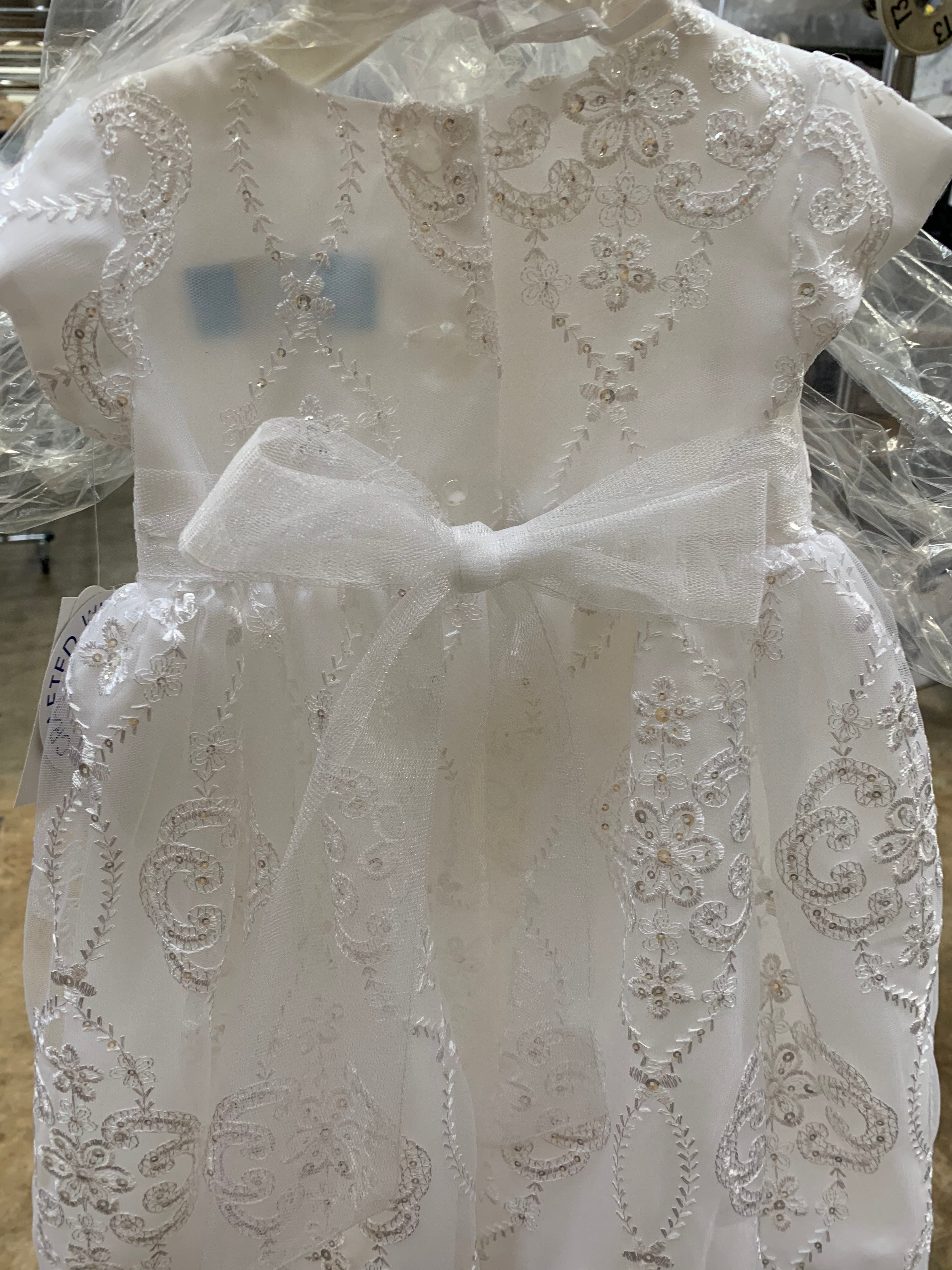 White lace dress on a mannequin with intricate patterns.