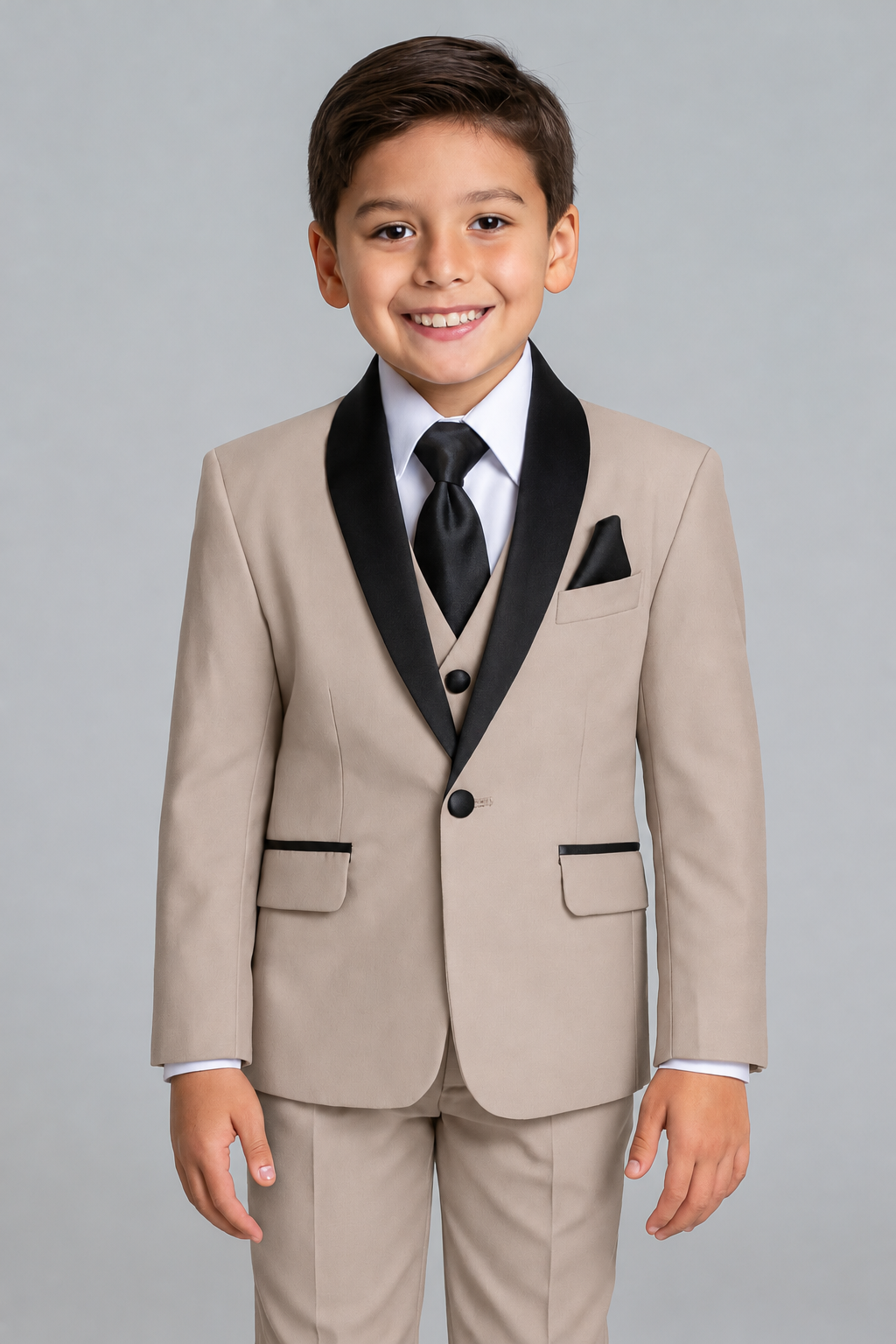 Young boy wearing a beige suit with black lapels and tie