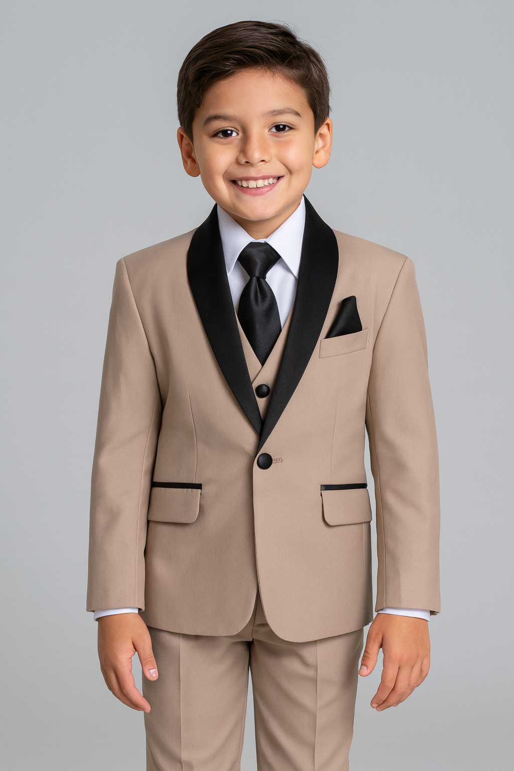 Young boy wearing a beige suit with black lapels and tie