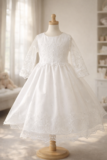 Elegant white lace dress for first communion, featuring long sleeves, floral embroidery, and a full layered skirt on a mannequin in a softly lit room.