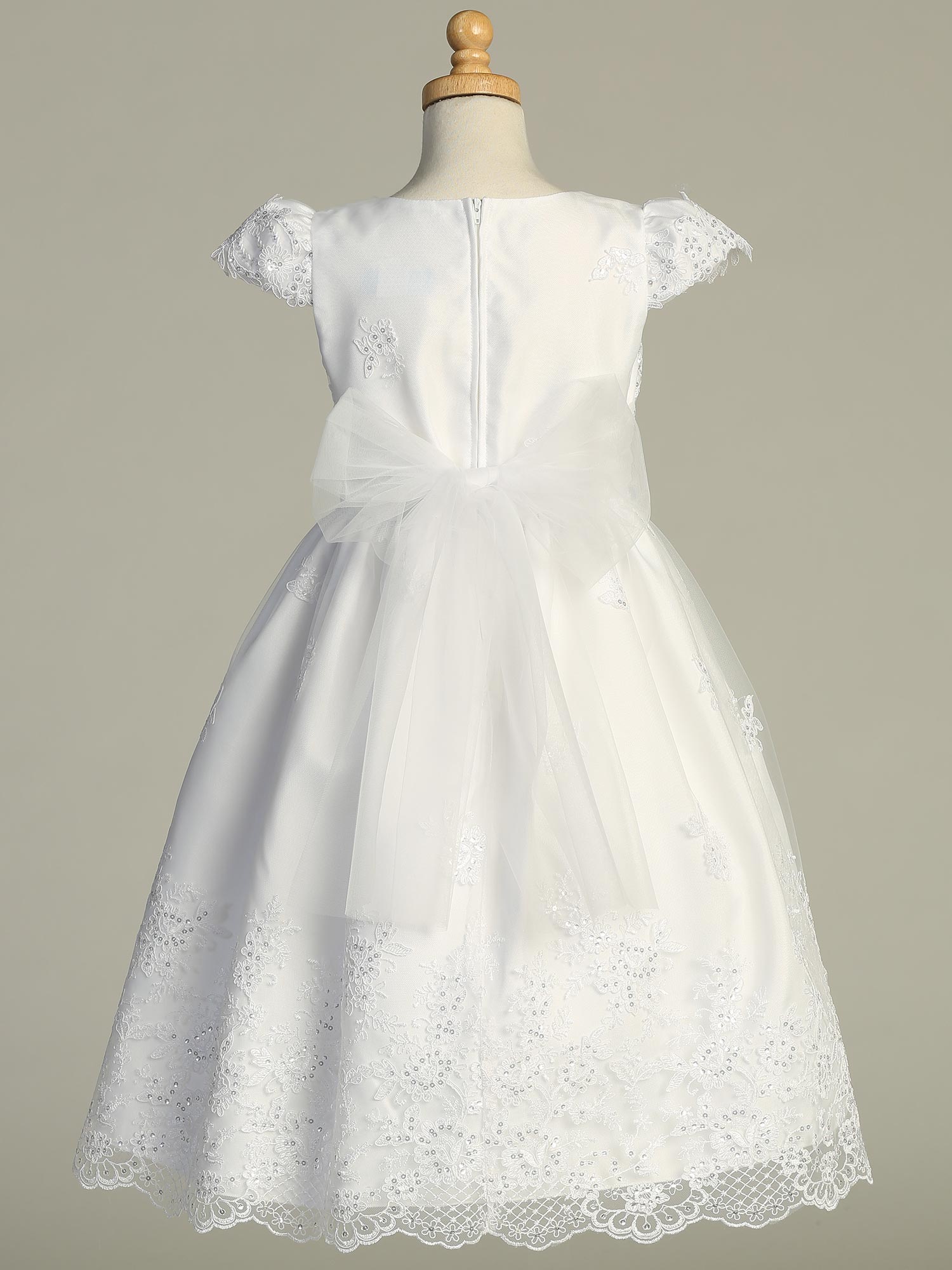 Back view of Elegant Girls' White First Communion Dress – Embroidered Tulle with large organza bow and zip closure, shown on mannequin.