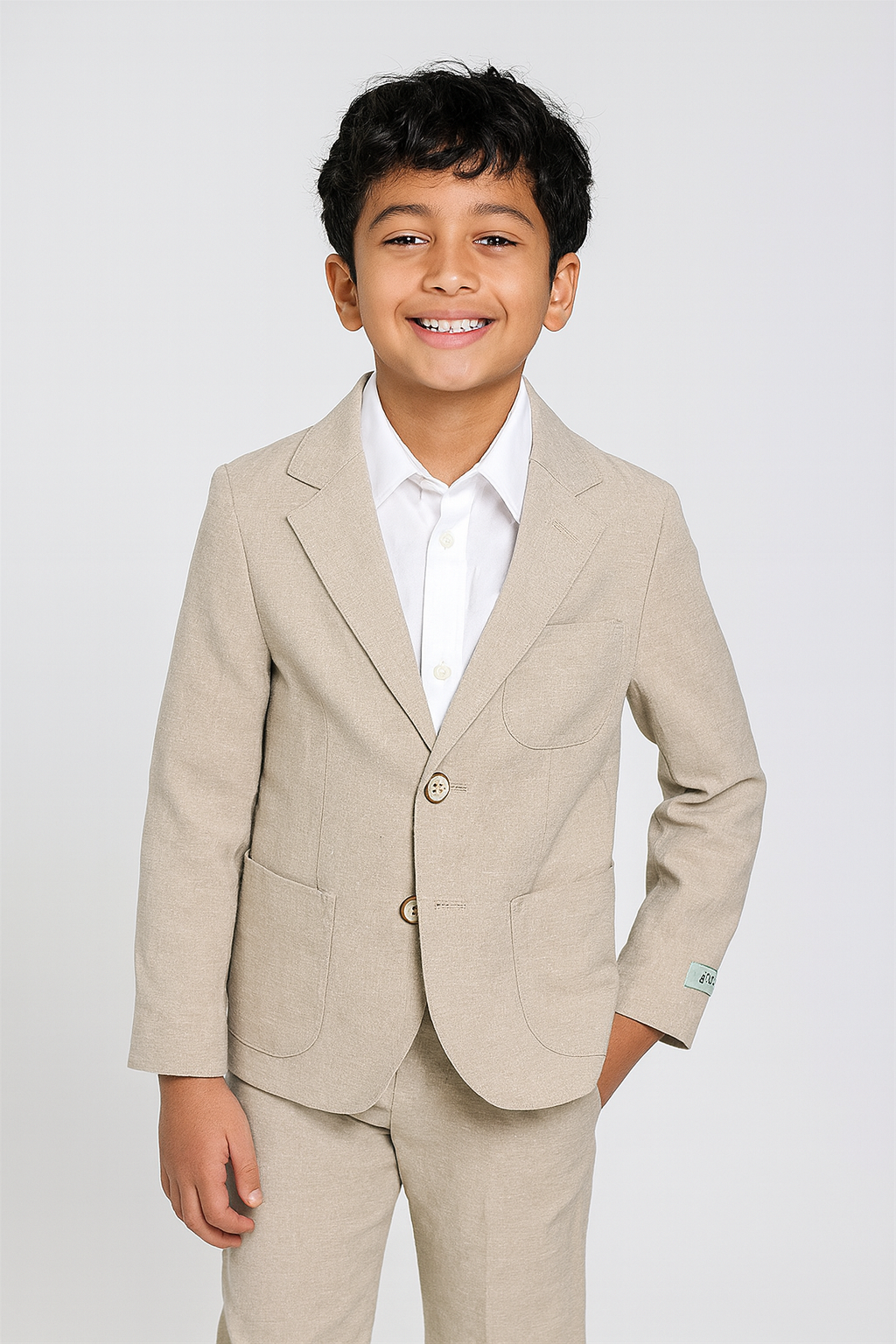 Young boy wearing a beige linen suit with a white shirt