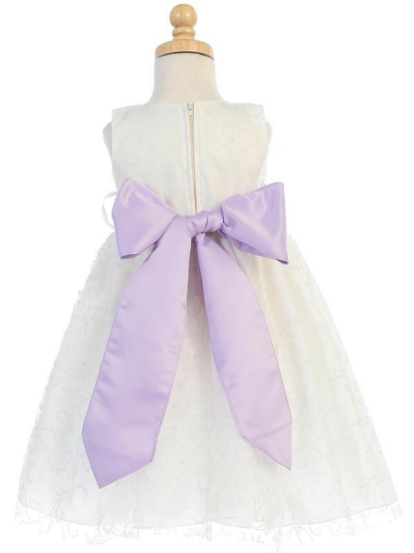 Back view of ivory glitter tulle flower girl dress featuring a large lilac bow sash and zip closure for elegant bridal party wear.