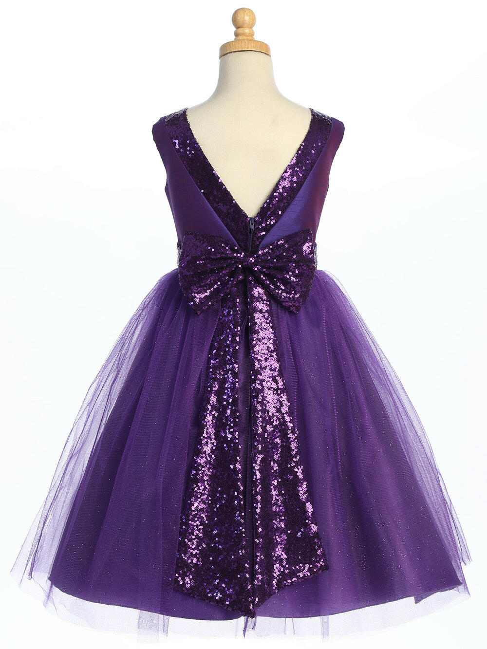 Back view of Purple Flower Girl Dress on mannequin featuring deep V-back, sequin bow, and shimmering tulle overlay for formal occasions.