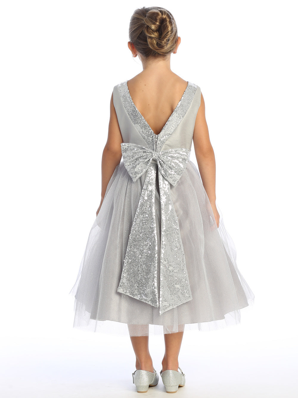 Sparkling sequins dance on silver shantung and tulle, enhancing a flower girl's grace.