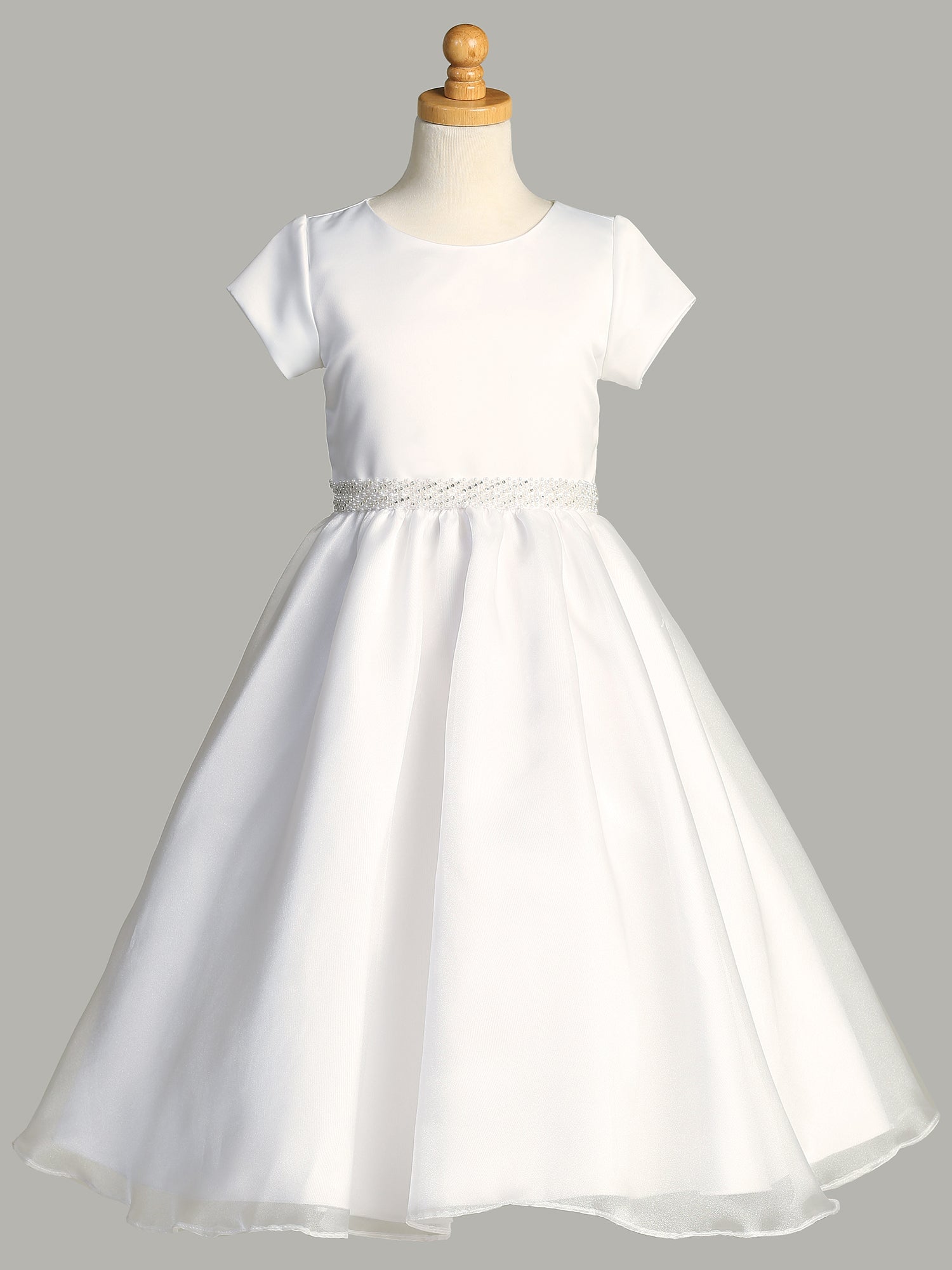 A side view of the First Communion Dress showing the cap sleeves and the tea-length of the dress.
