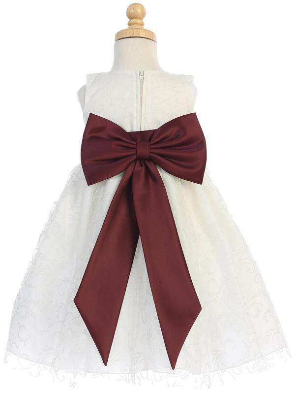 Back view of ivory glitter tulle flower girl dress featuring a large burgundy satin bow and zipper closure, perfect for bridal party attire.