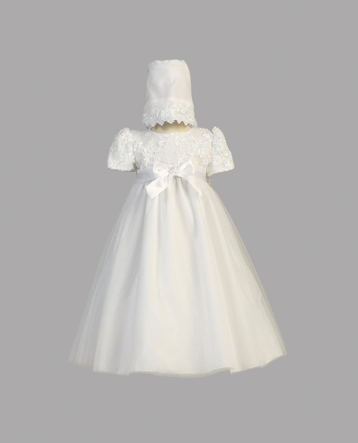 Girls' White Christening Gown Lillian with lace detailing and satin bow, shown with bonnet. A classic choice for baptism and traditional events.