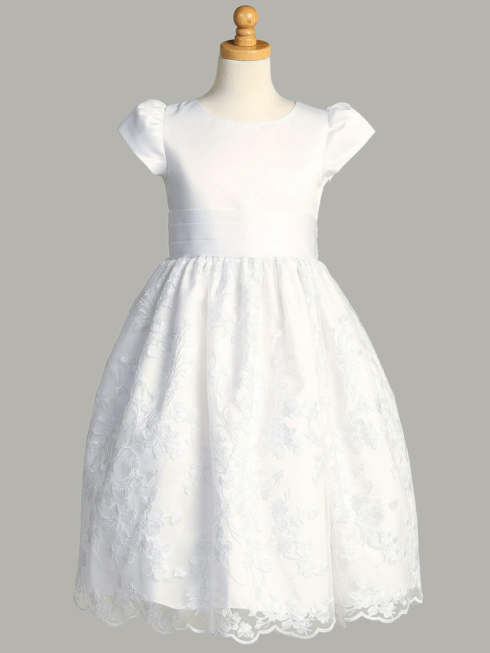 A side view of the First Communion Dress showing the satin bow on the waistline and the tea-length of the dress.