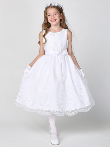 A girl wearing a graceful white First Communion Dress with embroidered tulle and sequins.