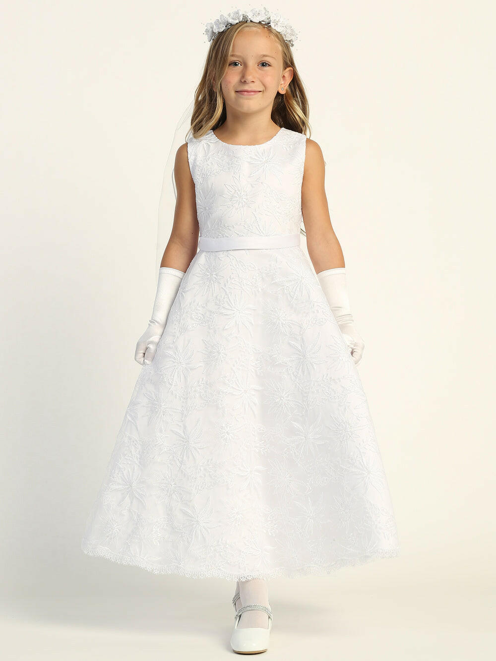 A girl wearing a stunning white First Communion Dress with embroidered tulle.