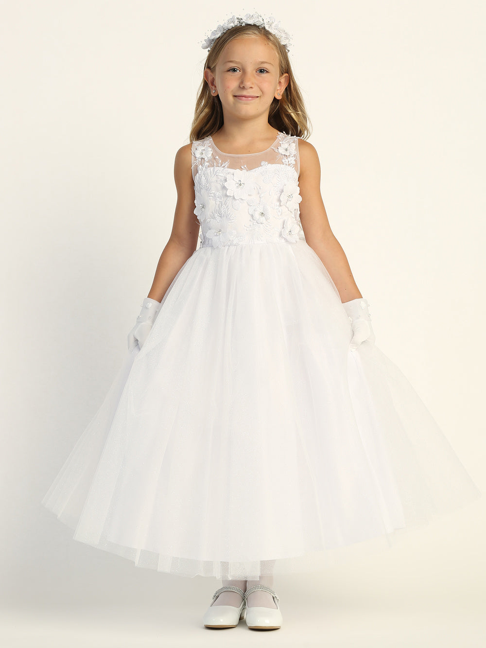 A girl wearing a beautiful white First Communion Dress with embroidered tulle and 3D flowers.
