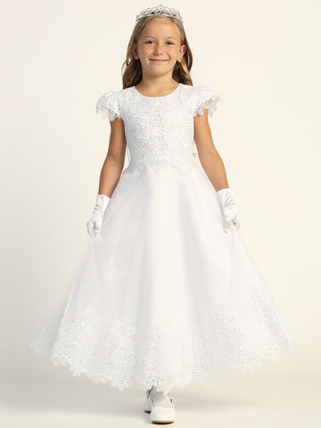 A girl wearing an elegant white First Communion Dress with embroidered tulle and sequins.