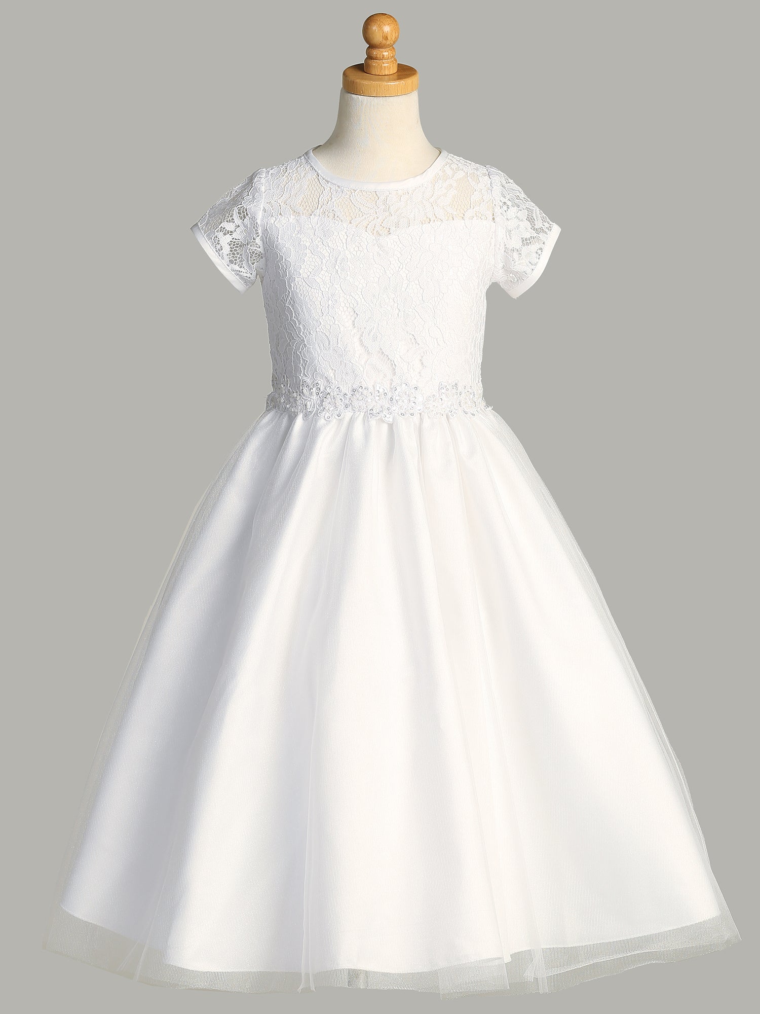 A side view of the First Communion Dress showing the tulle hard net for extra skirt volume and the tea-length of the dress.