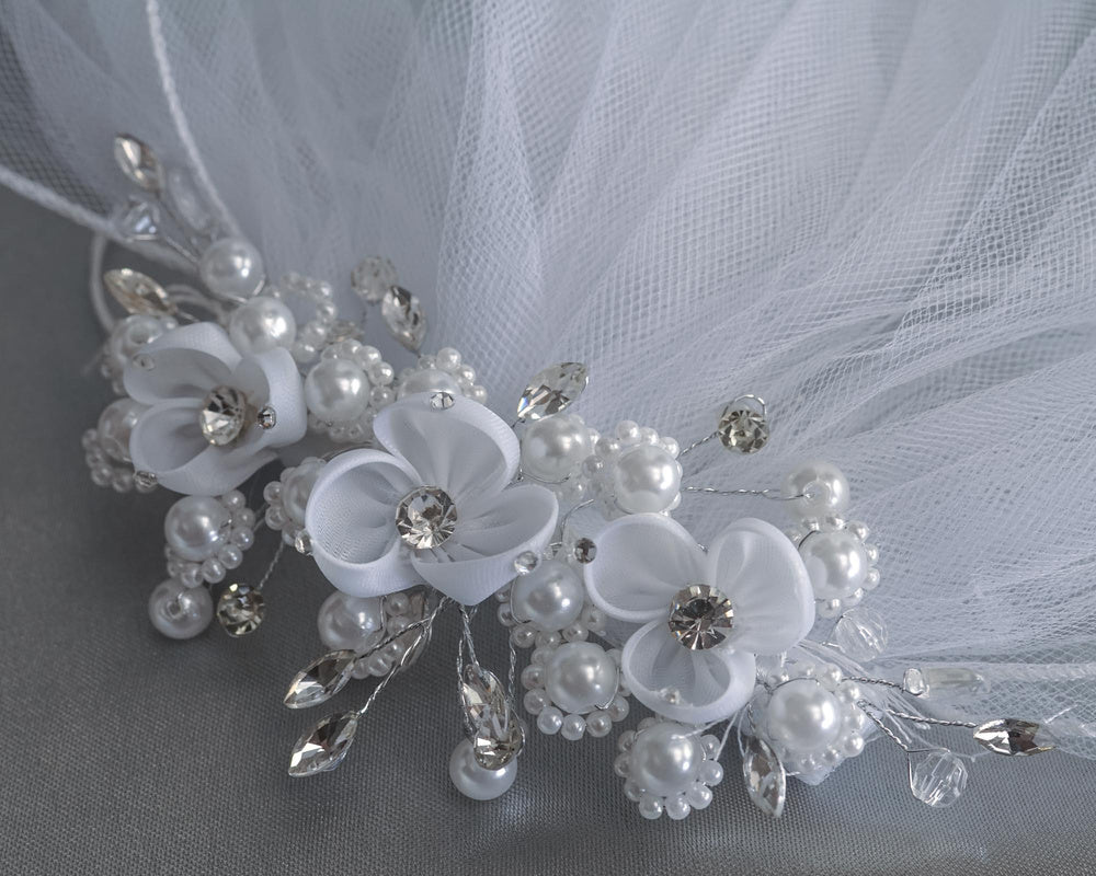Close-up of 24" Communion veil's floral headpiece adorned with organza flowers, rhinestones, pearls, and crystals for elegant detailing.