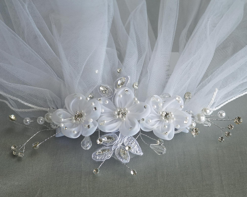 Detailed shot of 24" Communion veil headpiece adorned with organza flowers, pearls, rhinestones, and crystals. Perfect for a graceful, elegant look.