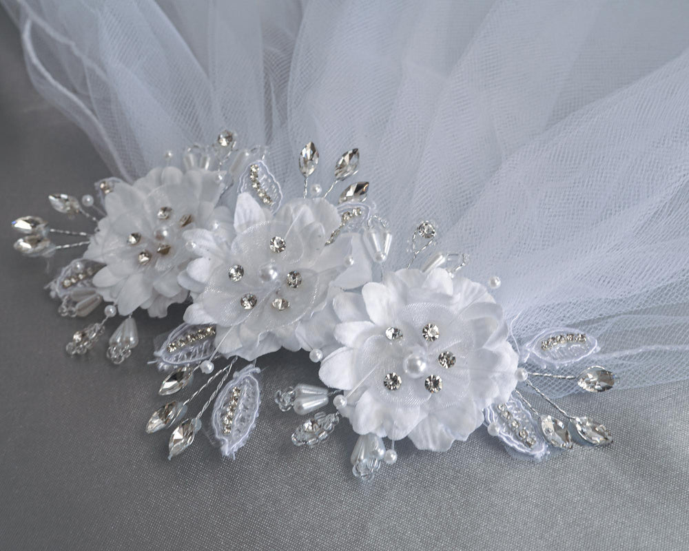 Close-up of elegant 24" communion veil featuring silk organza flowers adorned with pearls and rhinestones, ideal for special occasions.