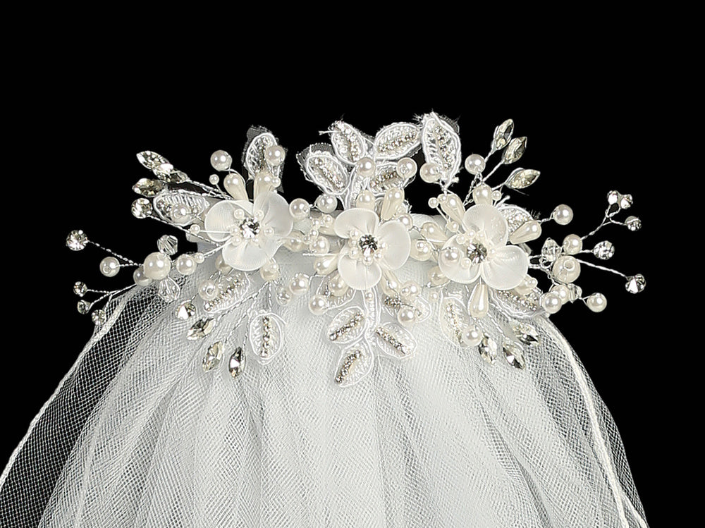 24" Communion veil with organza flowers, pearls, and rhinestones on a decorative headpiece. Ideal for girls' religious ceremonies.