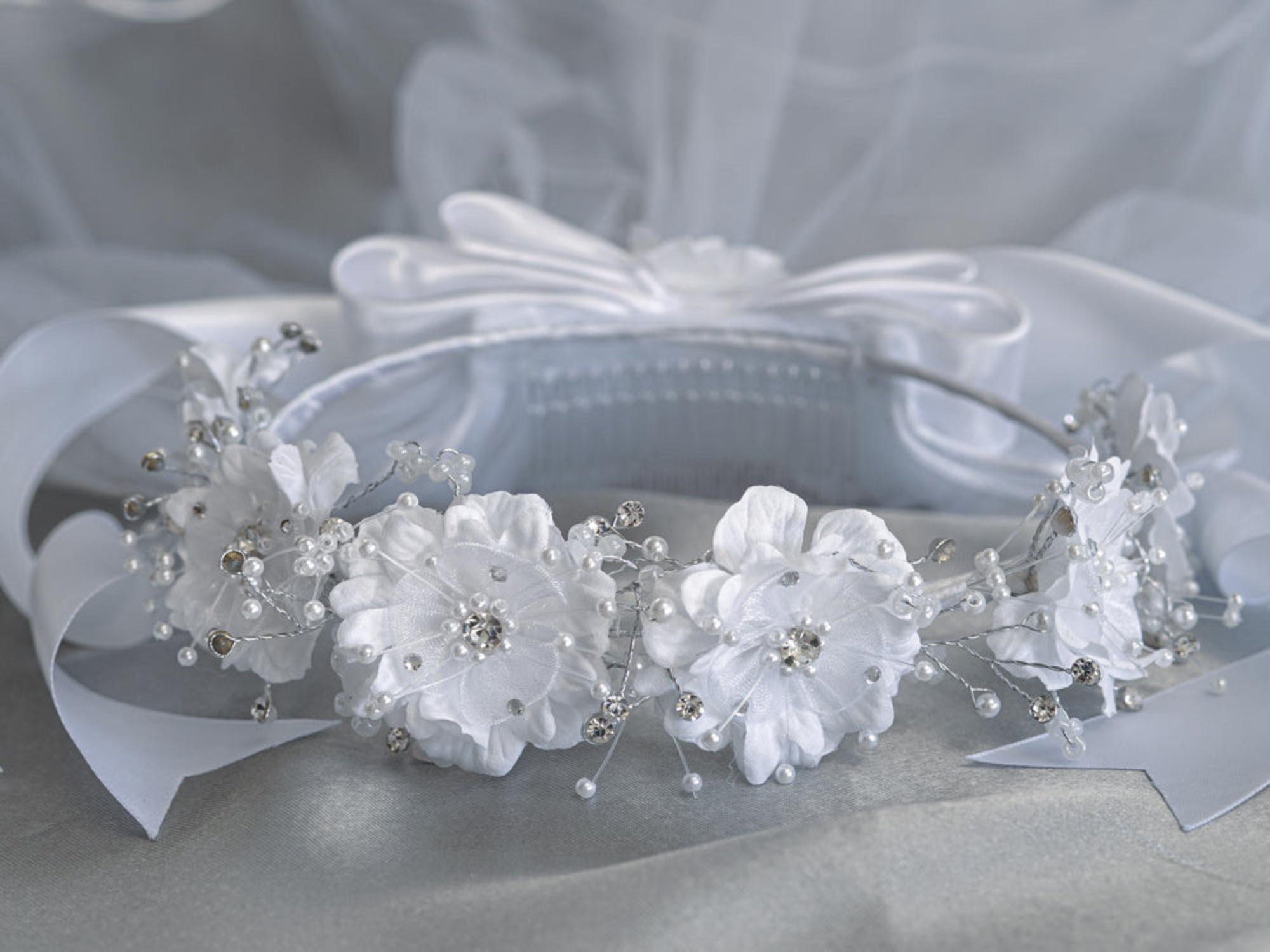 24" Communion Veil with silk organza flowers, pearls, and rhinestones on a comb. Features satin bows for a delicate, elegant ceremonial look.