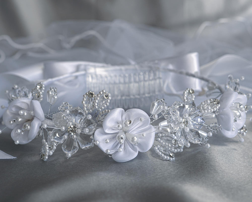 24" veil with satin crystal flowers, pearl rhinestones, and clear comb for secure fit. Ideal for girls' communion or religious ceremonies.