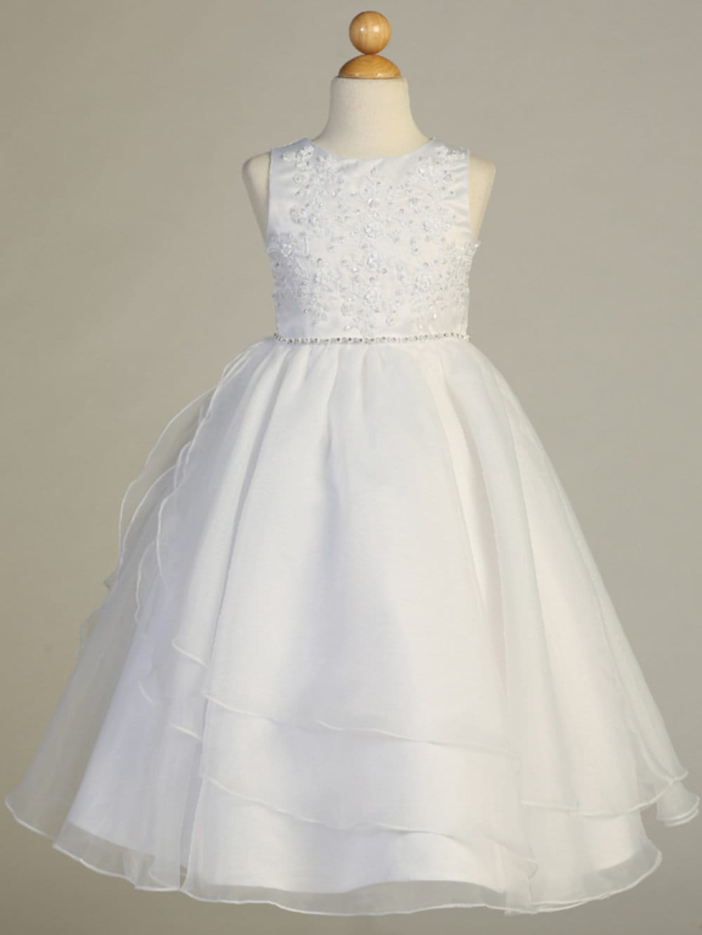 A full-length view of the First Communion Dress showing the tea-length and elegant silhouette.