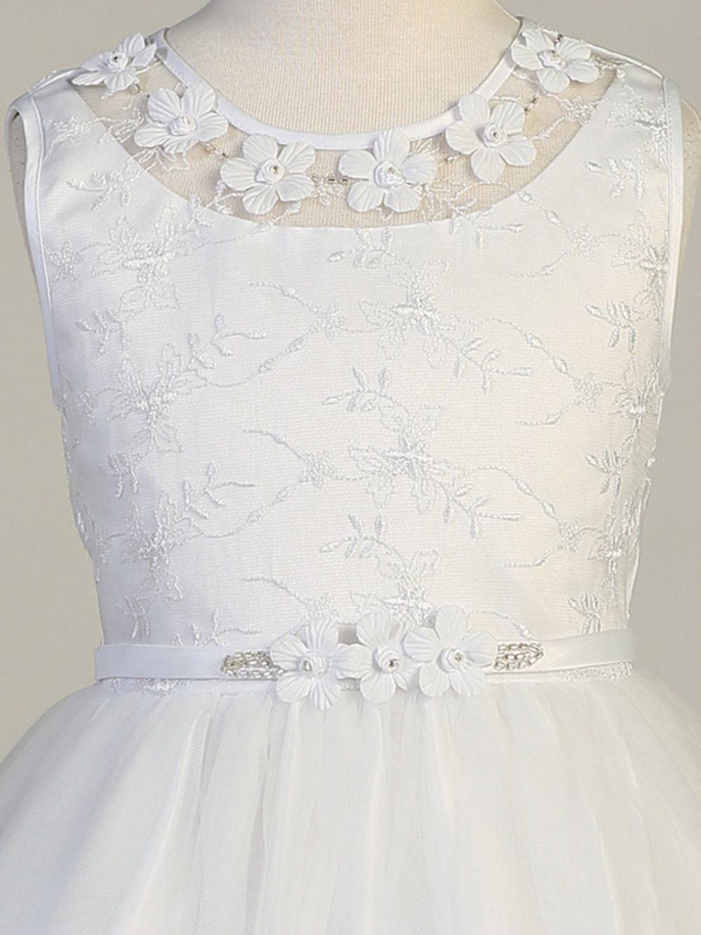 A view of the rhinestones and flower at the waist and the tulle skirt with embroidered edges.