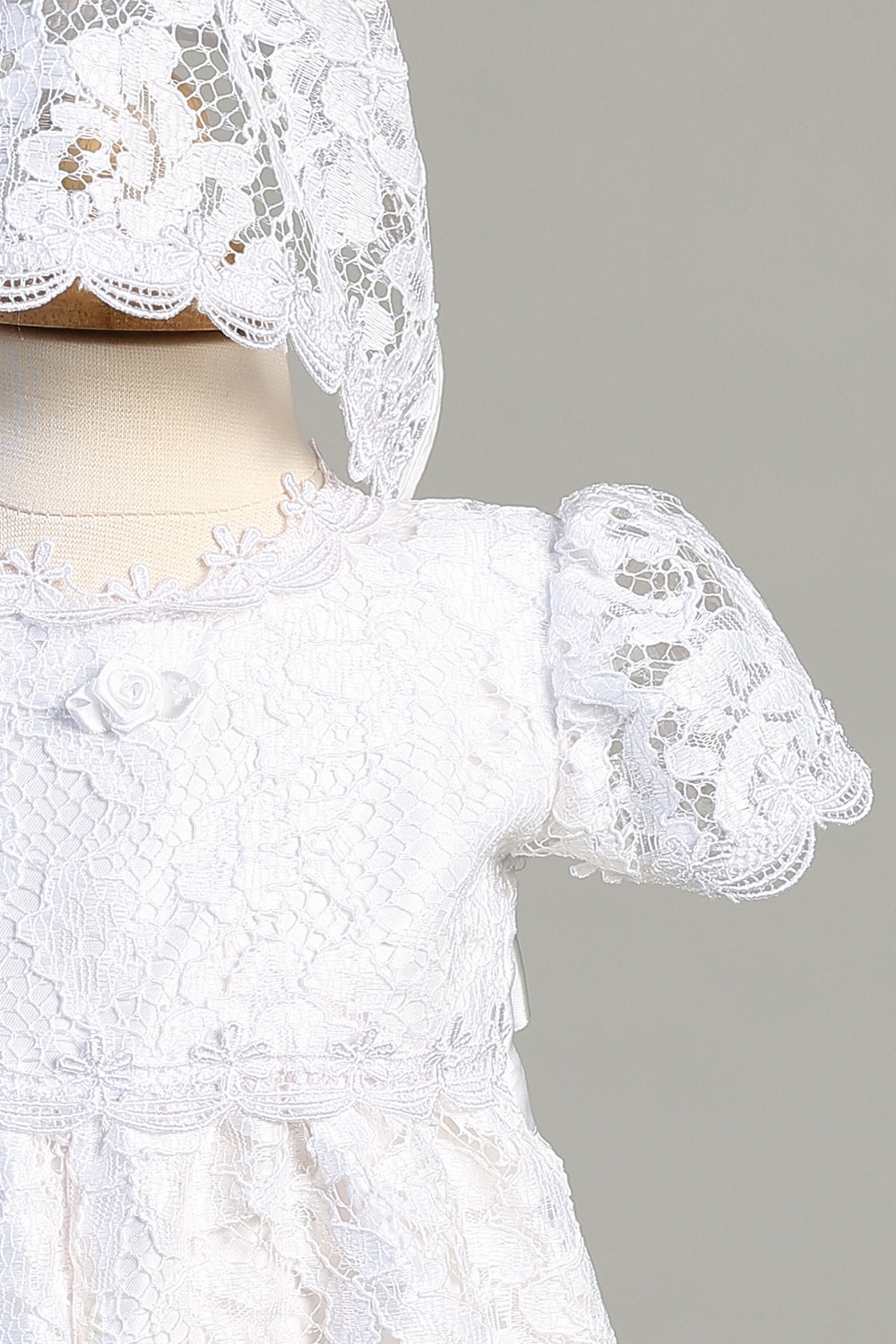 Close-up of Hazel White Christening Romper showing delicate floral lace, puff sleeves, and rosebud detail, perfect for infant baptism events.
